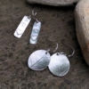 silver dangly earrings with stamped hearts and leaf print