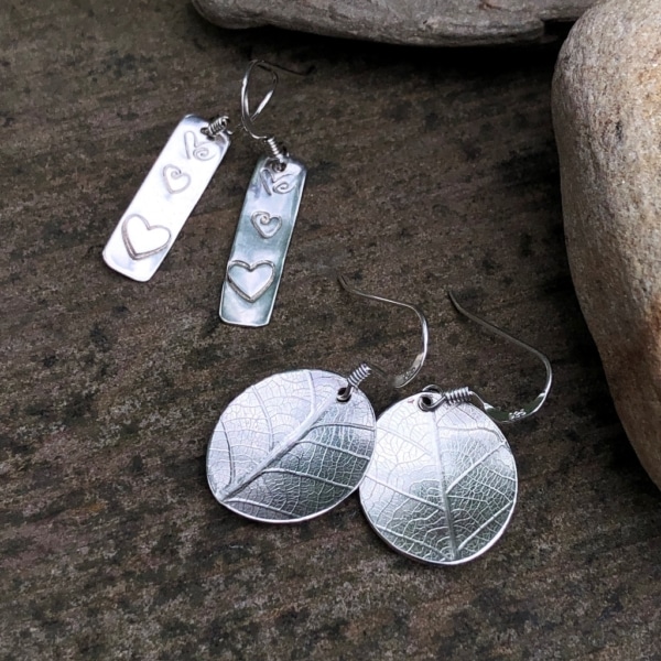 silver earrings with leaf print and hearts.