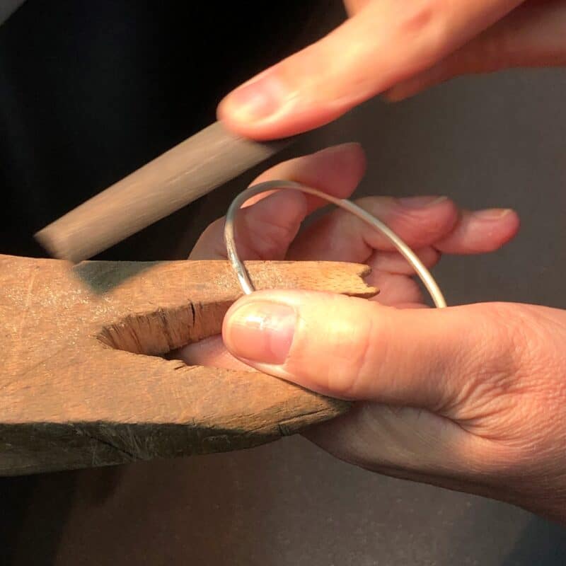 Filing a silver bangle at the benchpeg