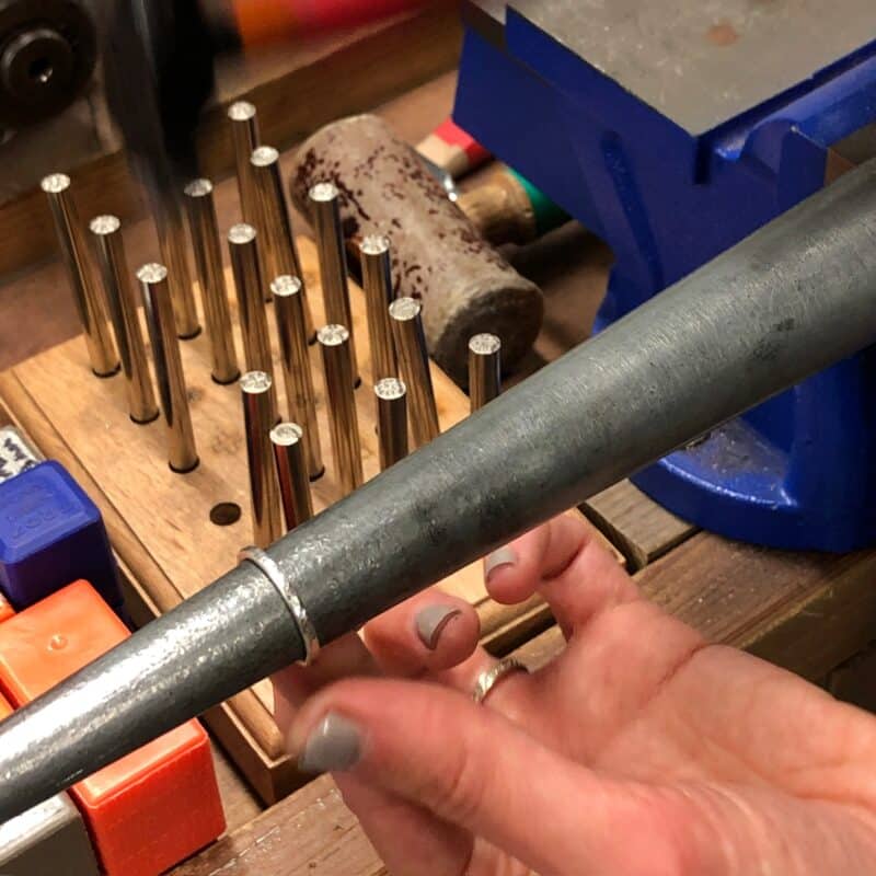 Hammering a silver ring on a ring mandrel