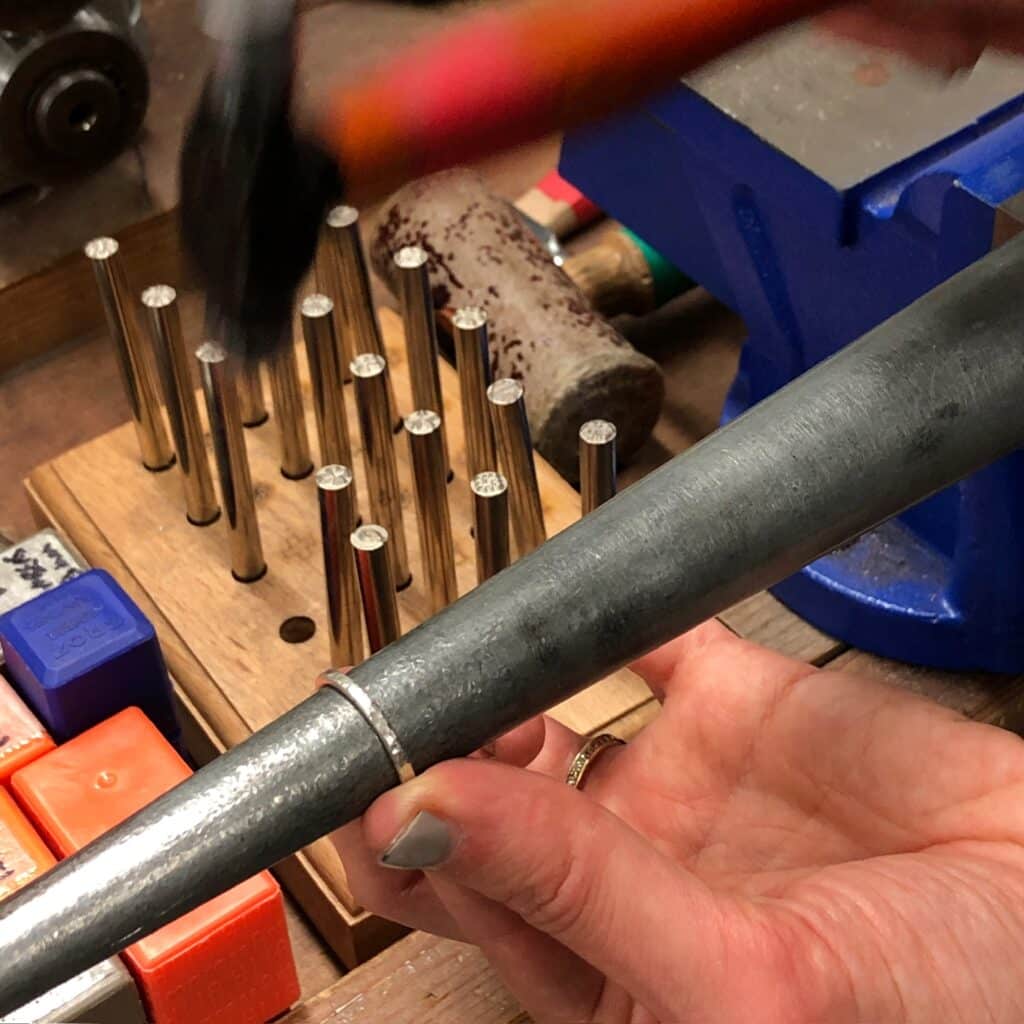 Hammering a silver ring on a mandrel