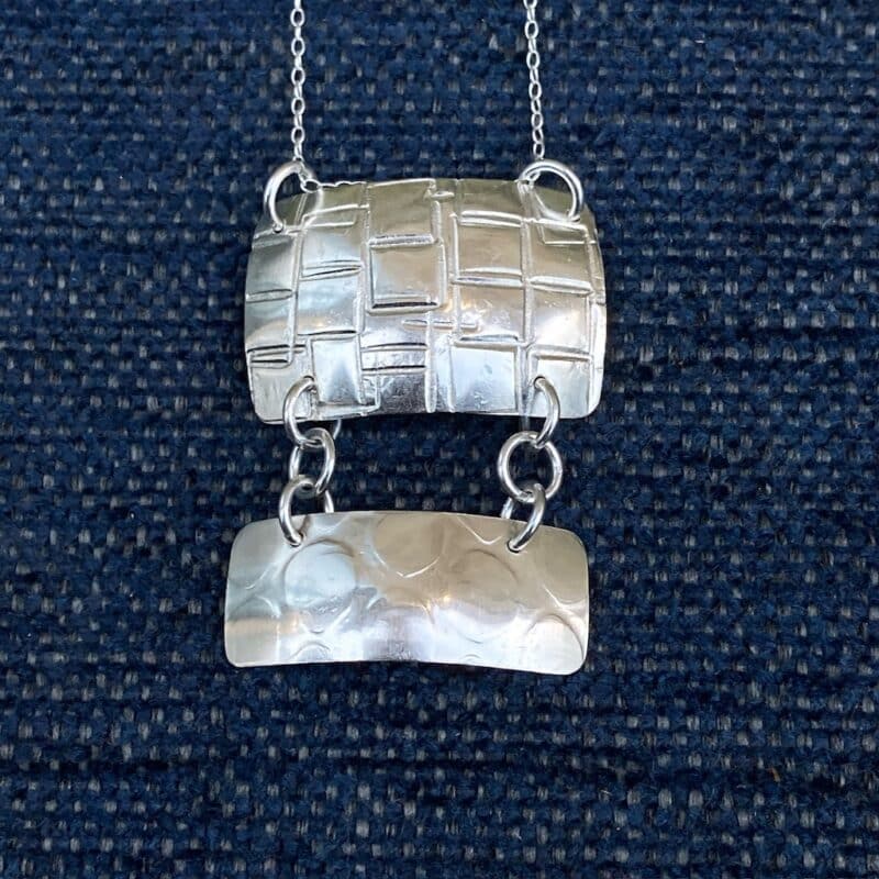 Silver pendant with textured surface and dangle
