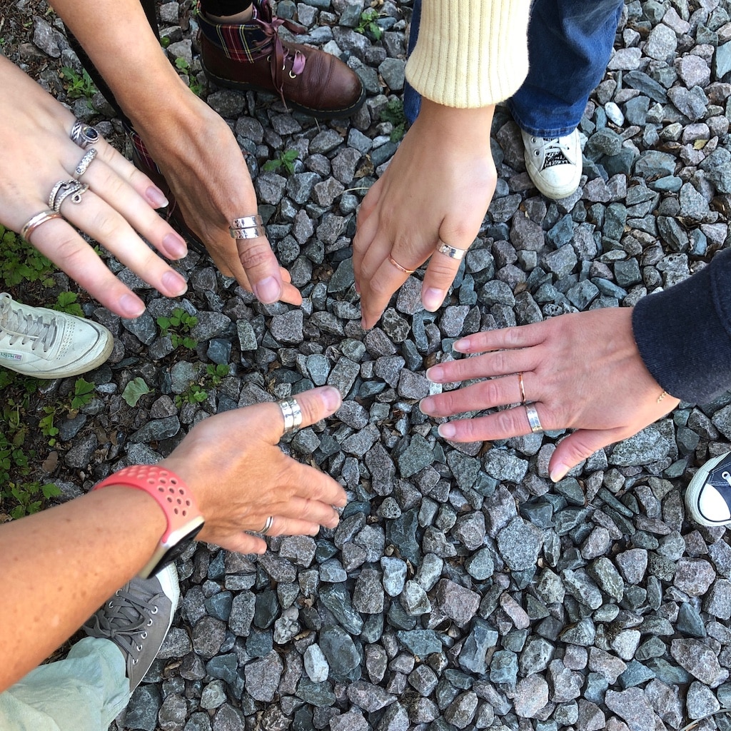 Many hands wearing silver and copper rings