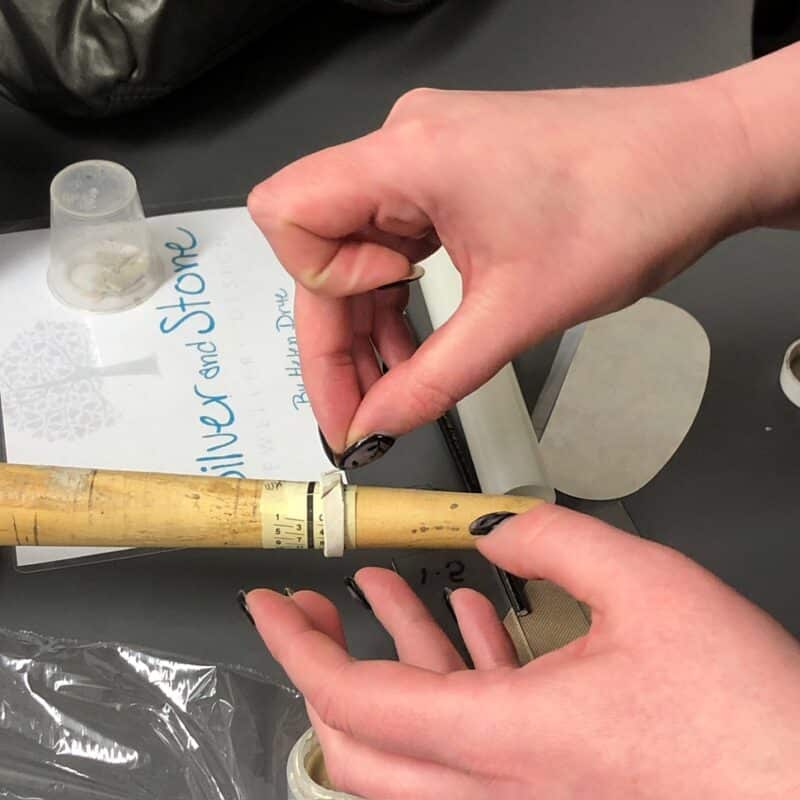 Student adding details to the silver clay ring, working on the ring stick