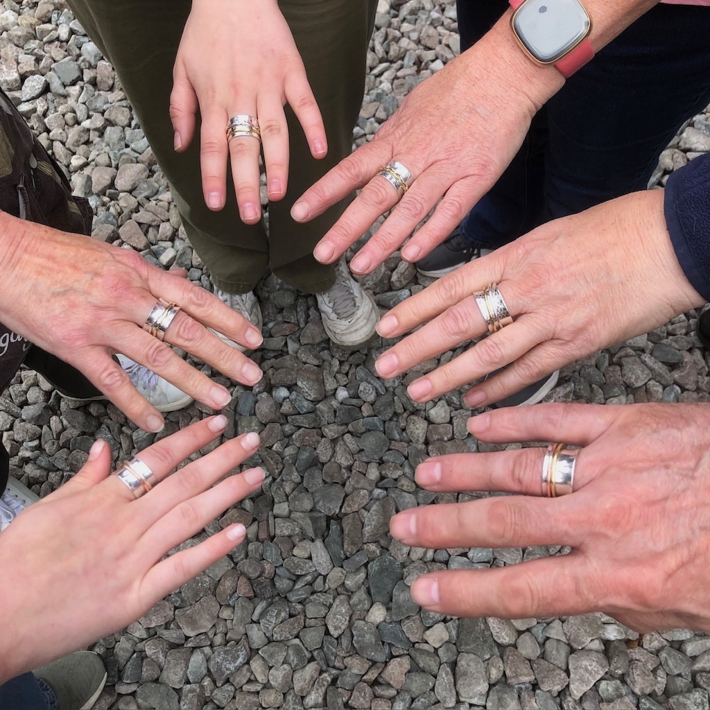Hands in a circle wearing spinner rings