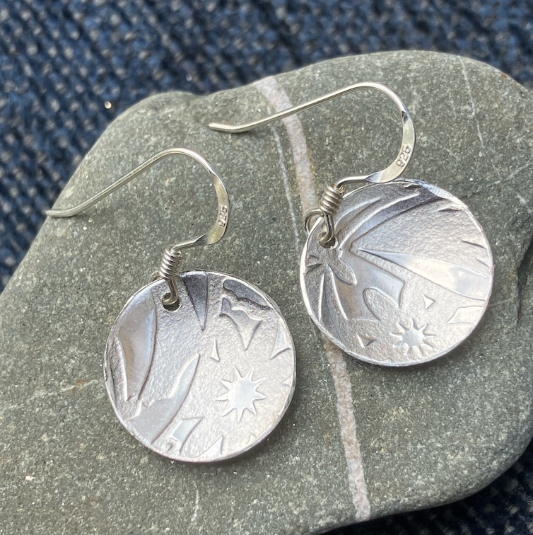 Silver earrings on stone