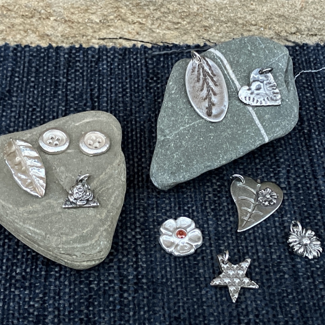 Silver clay pieces on stone and blue background