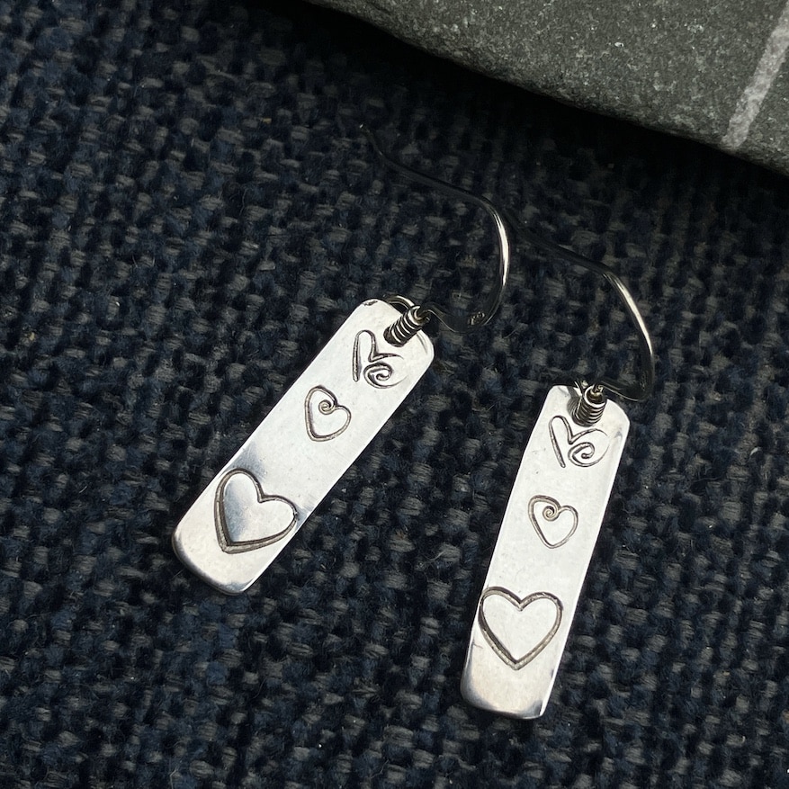 Silver earrings with heart stamped detail